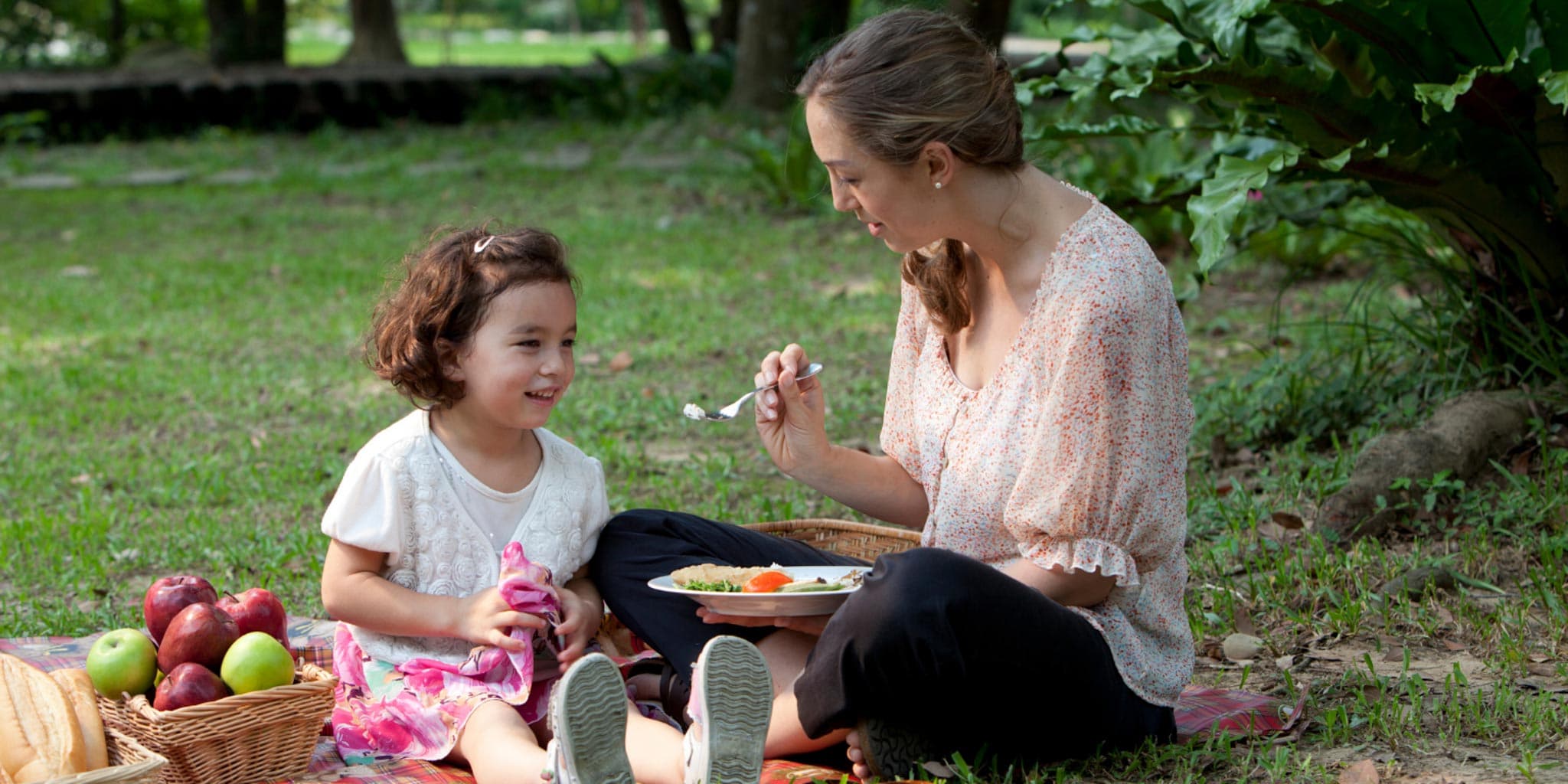 A woman feeding her child from the spoon. 